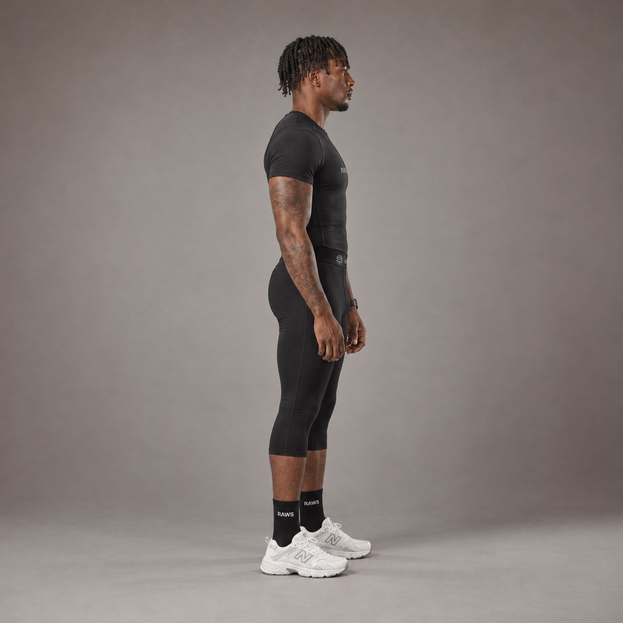 Model wearing the RAWS Basketball Compression T-Shirt and Compression 3/4 Leggings in Black, side view