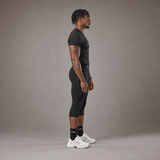 Model wearing the RAWS Basketball Compression T-Shirt and Compression 3/4 Leggings in Black, side view