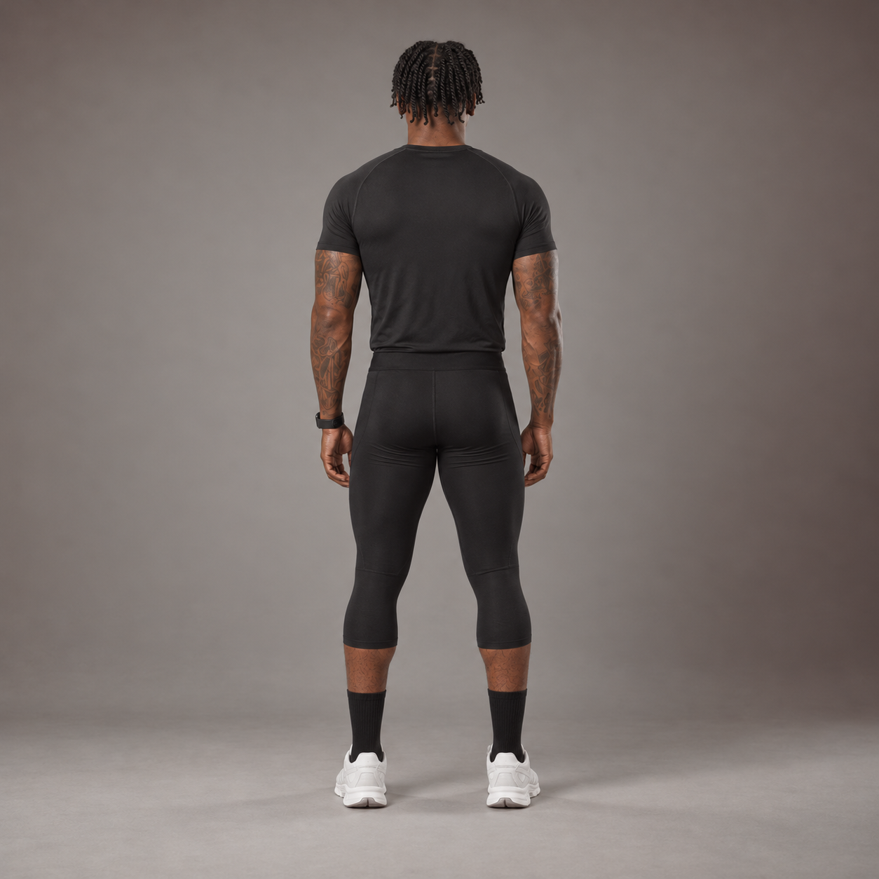 Model wearing the RAWS Basketball Compression T-Shirt and Compression 3/4 Leggings in Black, back view