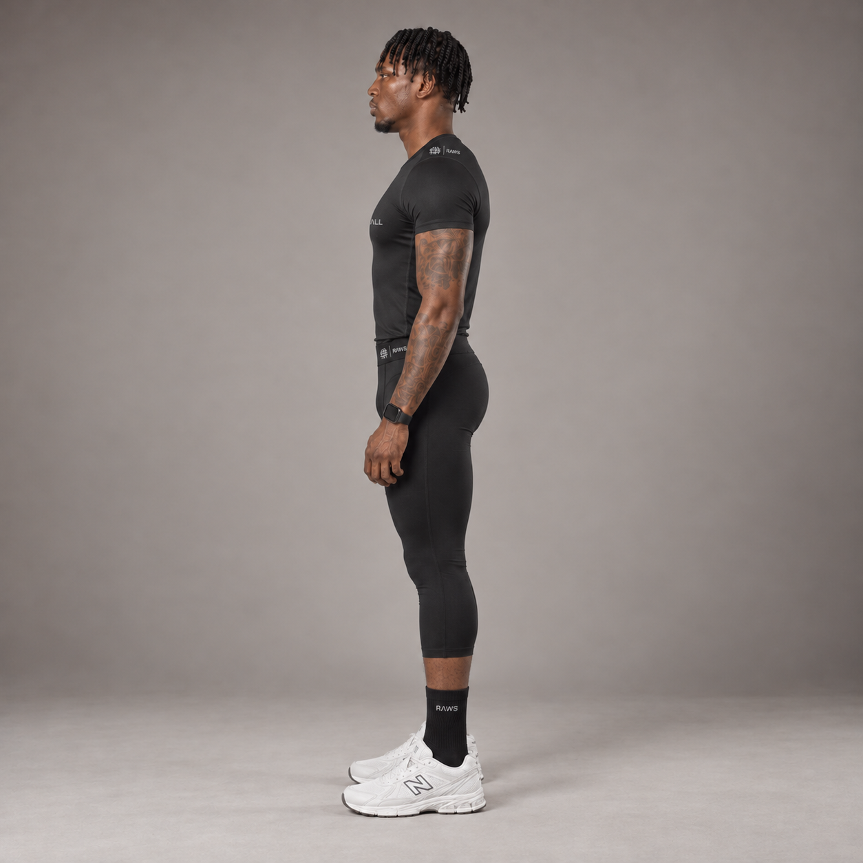 Model wearing the RAWS Basketball Compression T-Shirt and Compression 3/4 Leggings in Black, side view