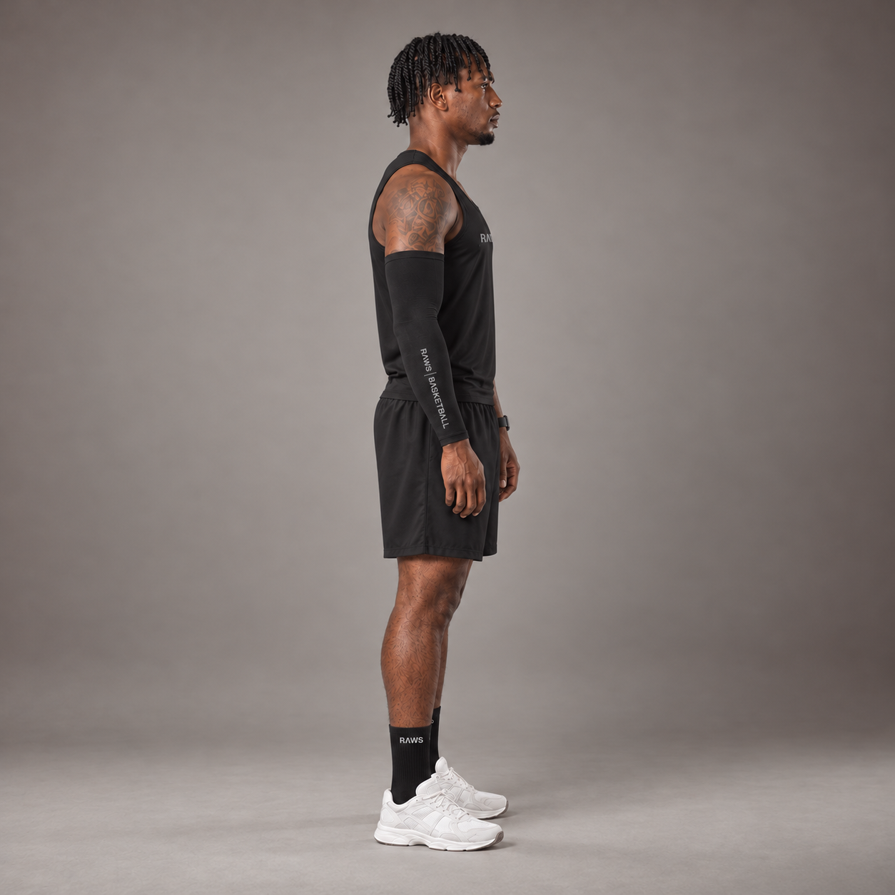 Model wearing the RAWS Basketball Vest in Black with Shooting Sleeve, Shooting Shorts and Socks, side view
