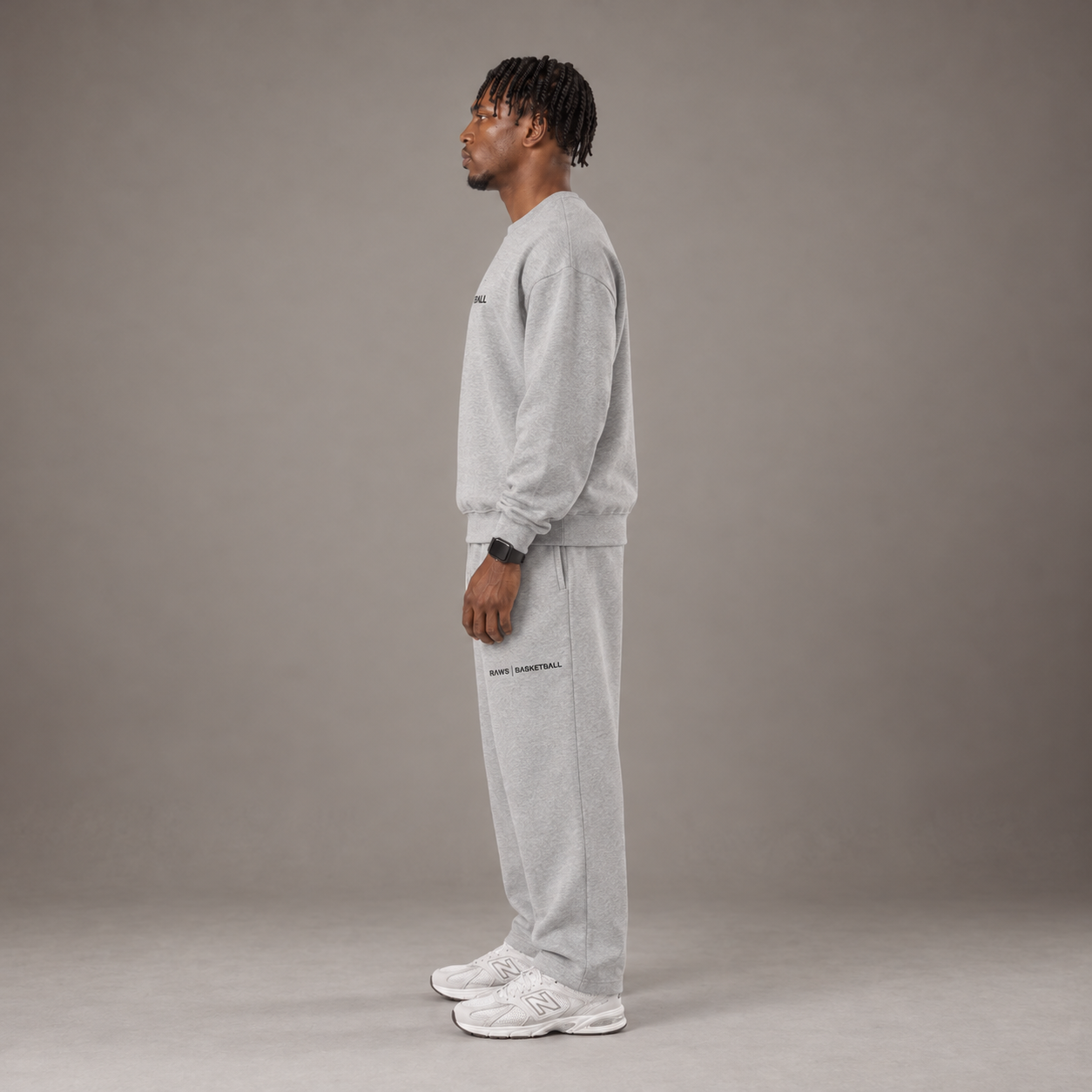 Model wearing the RAWS Off-Court Crew Sweatshirt and Joggers in Grey, side view