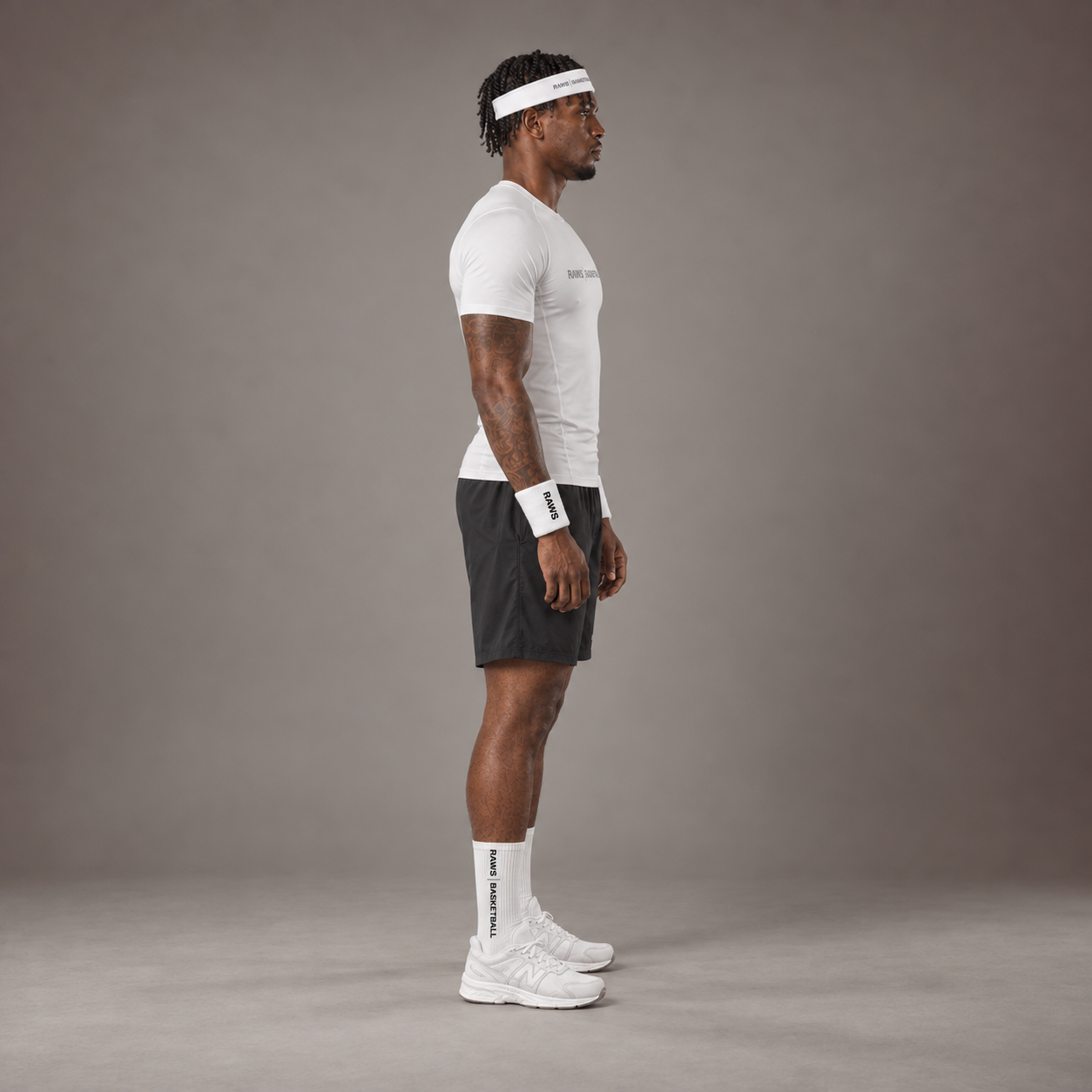 Model wearing the RAWS Basketball Compression T-Shirt in White with Headband, Sweatbands and Shooting Shorts, side view