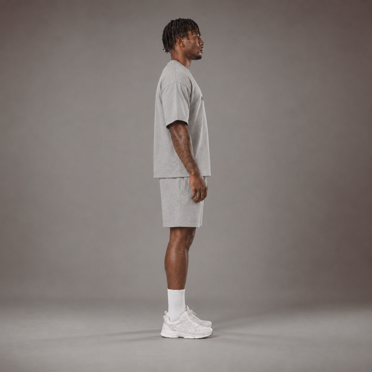 Model wearing the RAWS Off-Court T-Shirt and Shorts in Grey, side view