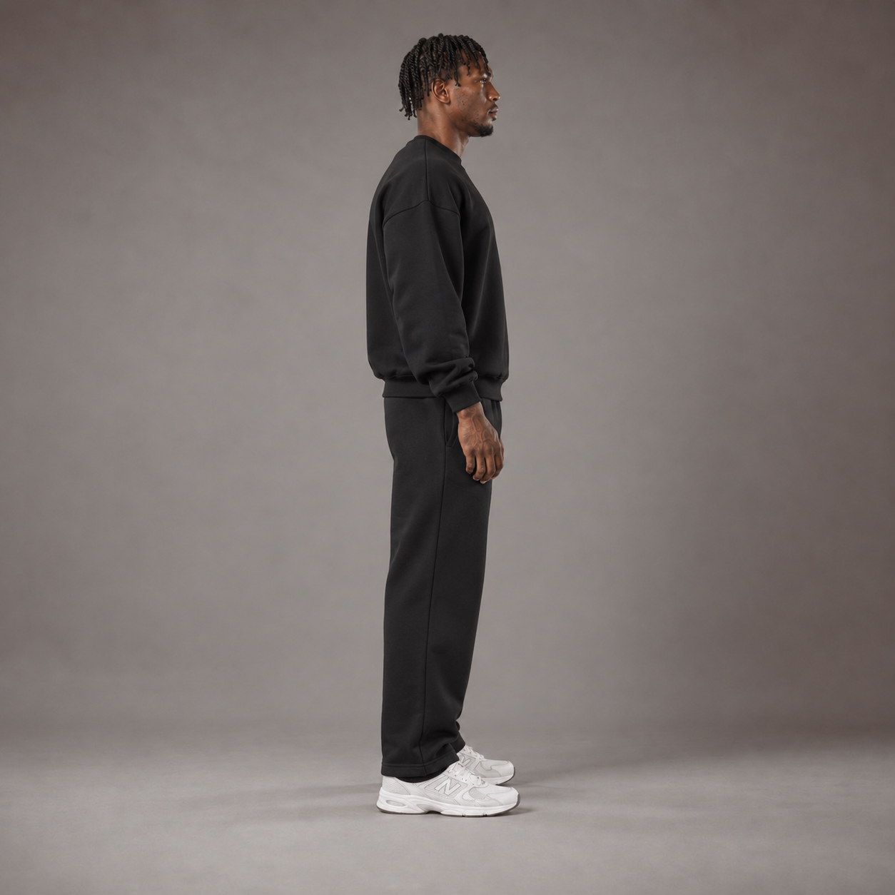 Model wearing the RAWS Off-Court Crew Sweatshirt and Joggers in Black, side view