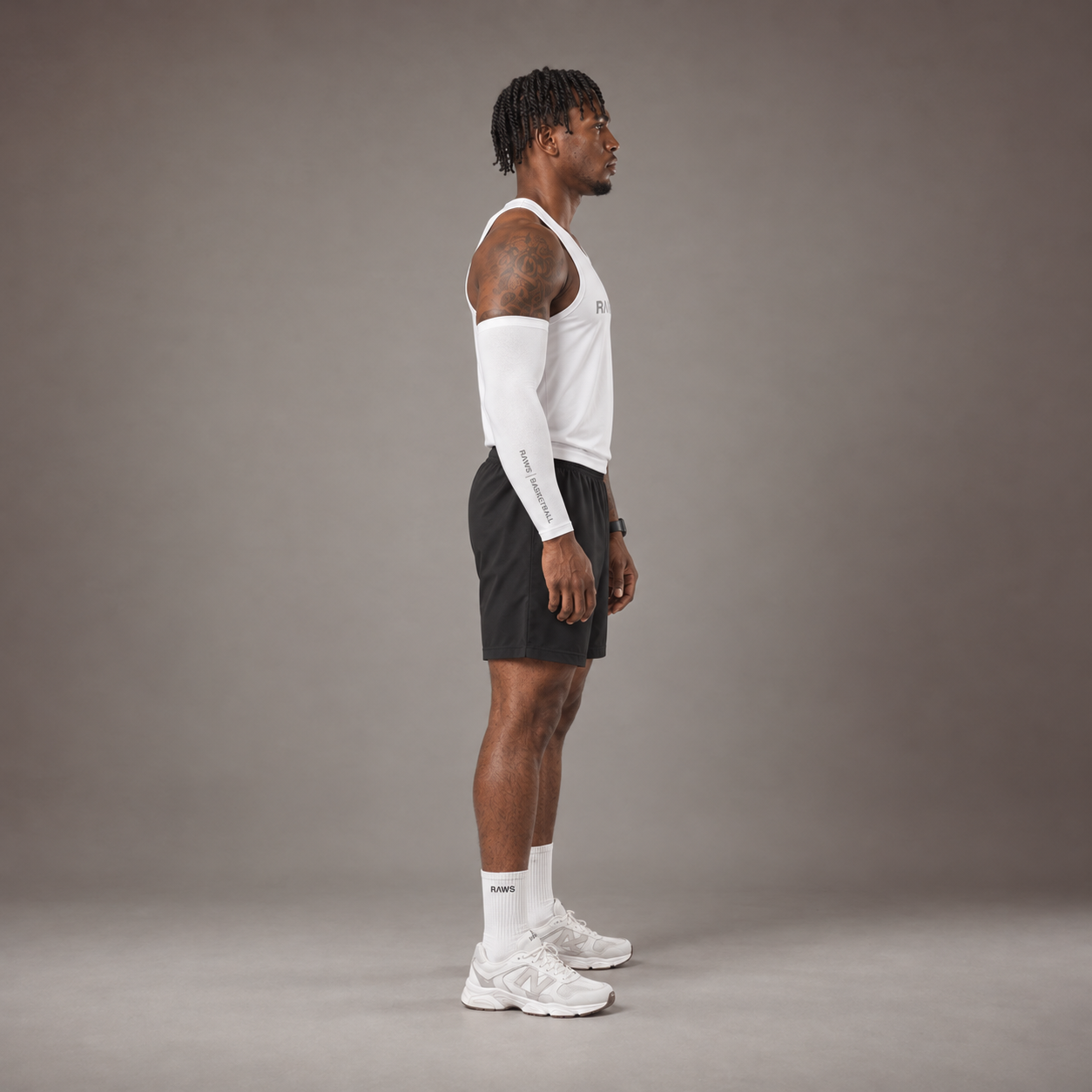 Model wearing the RAWS Basketball Vest in White with Shooting Sleeve, Shooting Shorts and Socks, side view