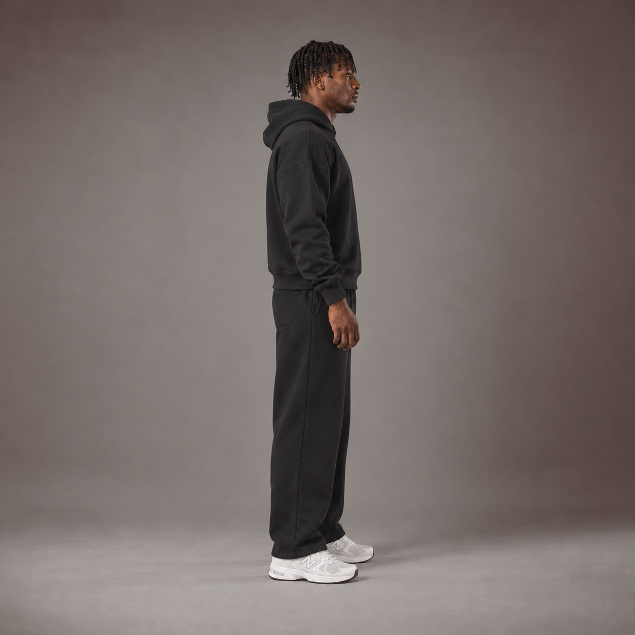 Model wearing the RAWS Off-Court Hoodie and Joggers in Black, side view
